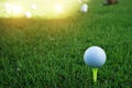 Golf ball on tee ready to be shot. golf ball on tee in the evening golf course with sunshine Royalty Free Stock Photo