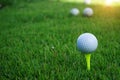 Golf ball on tee ready to be shot. golf ball on tee in the evening golf course with sunshine Royalty Free Stock Photo