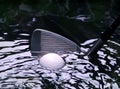 Golf ball on a water hazzard with iron club Royalty Free Stock Photo