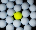 Golf balls. Single yellow ball mixed within many white balls. Royalty Free Stock Photo