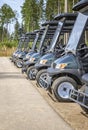 Golf cars or golf carts parked in a row outdoors on a sunny day. Royalty Free Stock Photo