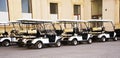 Golf cars or golf carts in a row outdoors on a sunny spring day Royalty Free Stock Photo