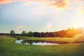 Golf cars on trimmed lawn, game course at sunset Royalty Free Stock Photo