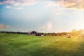 Golf cars on trimmed lawn, game course at sunset Royalty Free Stock Photo