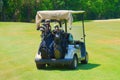 Golf cart with clubs loaded in back