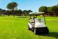 Golf cart in fairway of golf course with green grass field with blue sky and trees Royalty Free Stock Photo