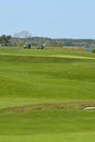 Golf carts and players on course at country club Royalty Free Stock Photo