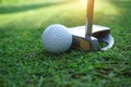 Golf club and golf ball close up in grass field with sunset Royalty Free Stock Photo