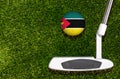 A golf club and a ball with flag Mozambique during a golf game