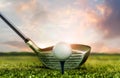 Golf club and ball on grass  under sunset sky lights Royalty Free Stock Photo