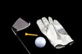 Golf Club with Glove Ball and Tee on Black Background Royalty Free Stock Photo