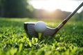 Golf club and golf ball close up in grass field with sunset Royalty Free Stock Photo