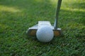 Golf club and golf ball close up in grass field with sunset Royalty Free Stock Photo