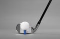 Golf Club Iron and Ball on a Blue Tee, photographed on a Lush Grey Background