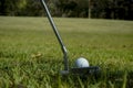 Golf clubs and ball on a green lawn in a beautiful golf course with morning sunshine Royalty Free Stock Photo