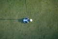 Golf clubs and ball on a green lawn in a beautiful golf course with morning sunshine Royalty Free Stock Photo