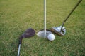 Golf clubs and ball on a green lawn in a beautiful golf course with morning sunshine Royalty Free Stock Photo