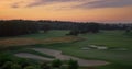 Golf course aerial view in evening pink sunset. Empty fairway green grass field. Royalty Free Stock Photo