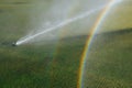 Golf course automatic lawn sprinkler with rainbow Royalty Free Stock Photo