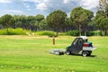 Golf course and golf cart collecting golf balls. Ballpicker on driving range of golf club Royalty Free Stock Photo