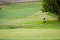 Golf course with one flag pole and trolley on fairway Royalty Free Stock Photo