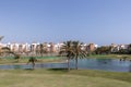 Golf course with palm trees, a lake and houses in the background in Playa Granada, Motril, Spain Royalty Free Stock Photo