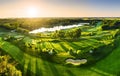 Golf course panorama at dramatic sunrise with green fairways and forest Royalty Free Stock Photo