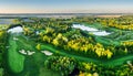 Golf course panorama at dramatic sunrise with green fairways and forest Royalty Free Stock Photo