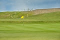 Golf course putting green with short grass and flag marking hole Royalty Free Stock Photo