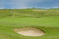 Golf course putting green with short grass and flag marking hole Royalty Free Stock Photo