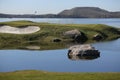 A golf course with roads and ponds and with flag