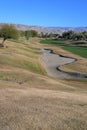 Golf Course sand traps and fairways with mountains in the background.