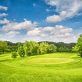 Golf course. Spring field with green grass and blue sky Royalty Free Stock Photo