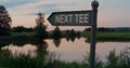 Golf course tee sign in empty golfing park. Show direction on sunset nature lake Royalty Free Stock Photo