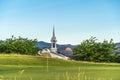 Golf course with trees church steeple mountain and blue sky background Royalty Free Stock Photo