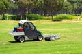 Golf course and a vehicle collecting golf balls. Ballpicker on driving range of golf club Royalty Free Stock Photo