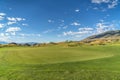 Golf course with vivid green fairway under blue sky and clouds on a sunny day Royalty Free Stock Photo