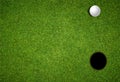 Golf day invitation, looking down on lawn with golf ball and hole Royalty Free Stock Photo