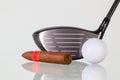 Golf driver and different cigars on a glass desk