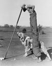 Golf game with man on stilts Royalty Free Stock Photo