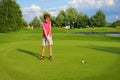 Golf, girl golfer driving ball into the hole Royalty Free Stock Photo