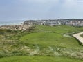 Golf hole by the ocean from the tee with flag by the sea in Portugal Royalty Free Stock Photo