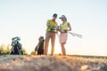 Golf instructor teaching a young woman how to use different golf clubs