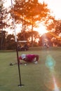 Golf player blowing ball in hole with sunset in background Royalty Free Stock Photo