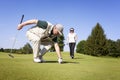 Golf player couple on green picking ball. Royalty Free Stock Photo