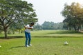 Golf player hitting shot with club on course Royalty Free Stock Photo