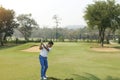 Golf player hitting shot with club on course Royalty Free Stock Photo