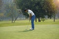 Golf player hitting shot with club on golf course Royalty Free Stock Photo