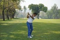 Golf player hitting shot with club on golf course Royalty Free Stock Photo