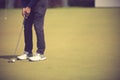 Golf player at the putting green hitting ball into a hole. Royalty Free Stock Photo